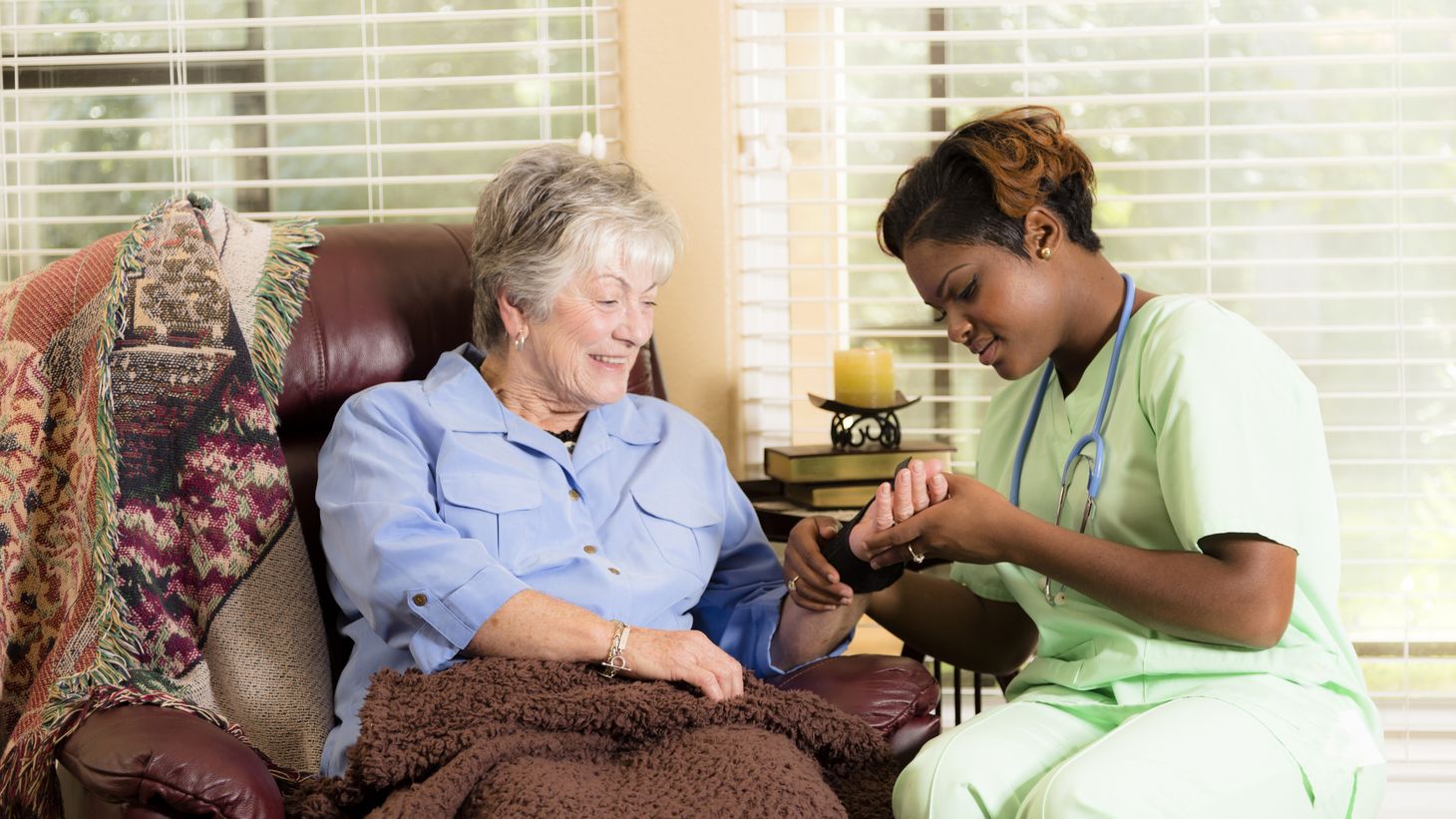 Nurse helping elderly woman at home