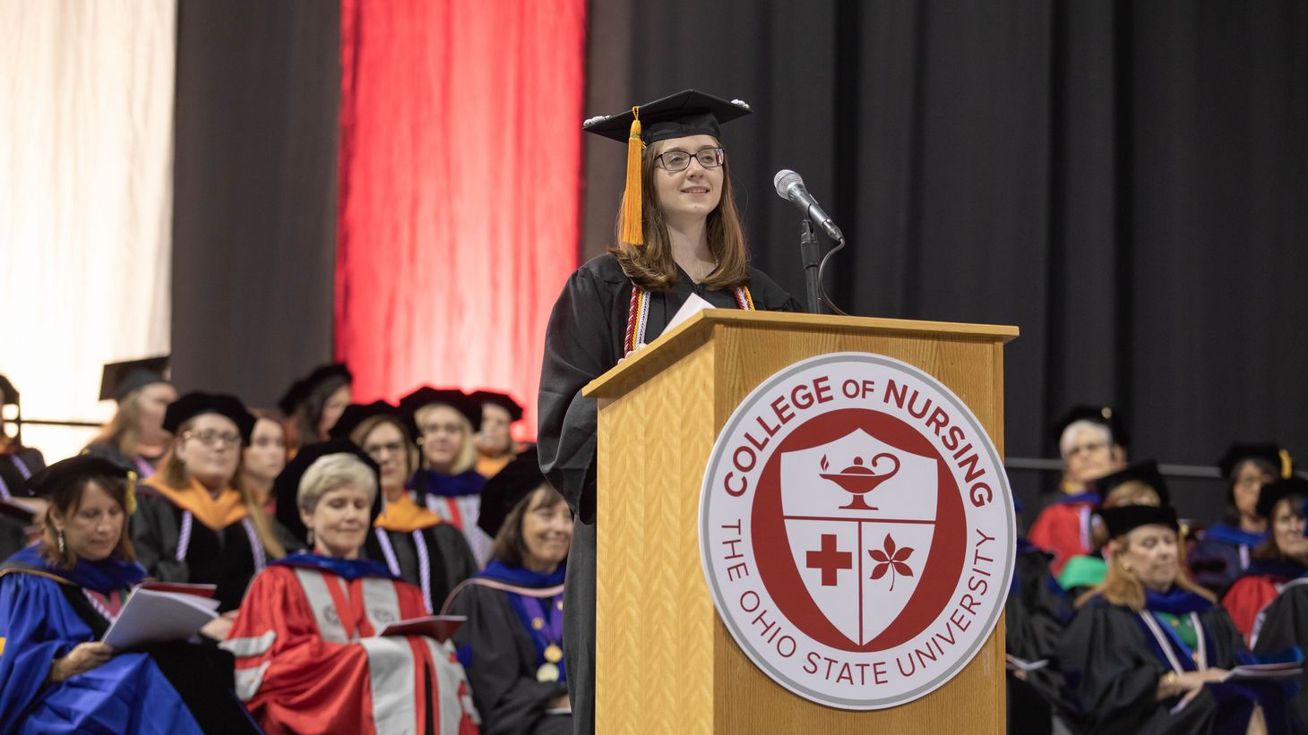 Student presenting at convocation ceremony on stage