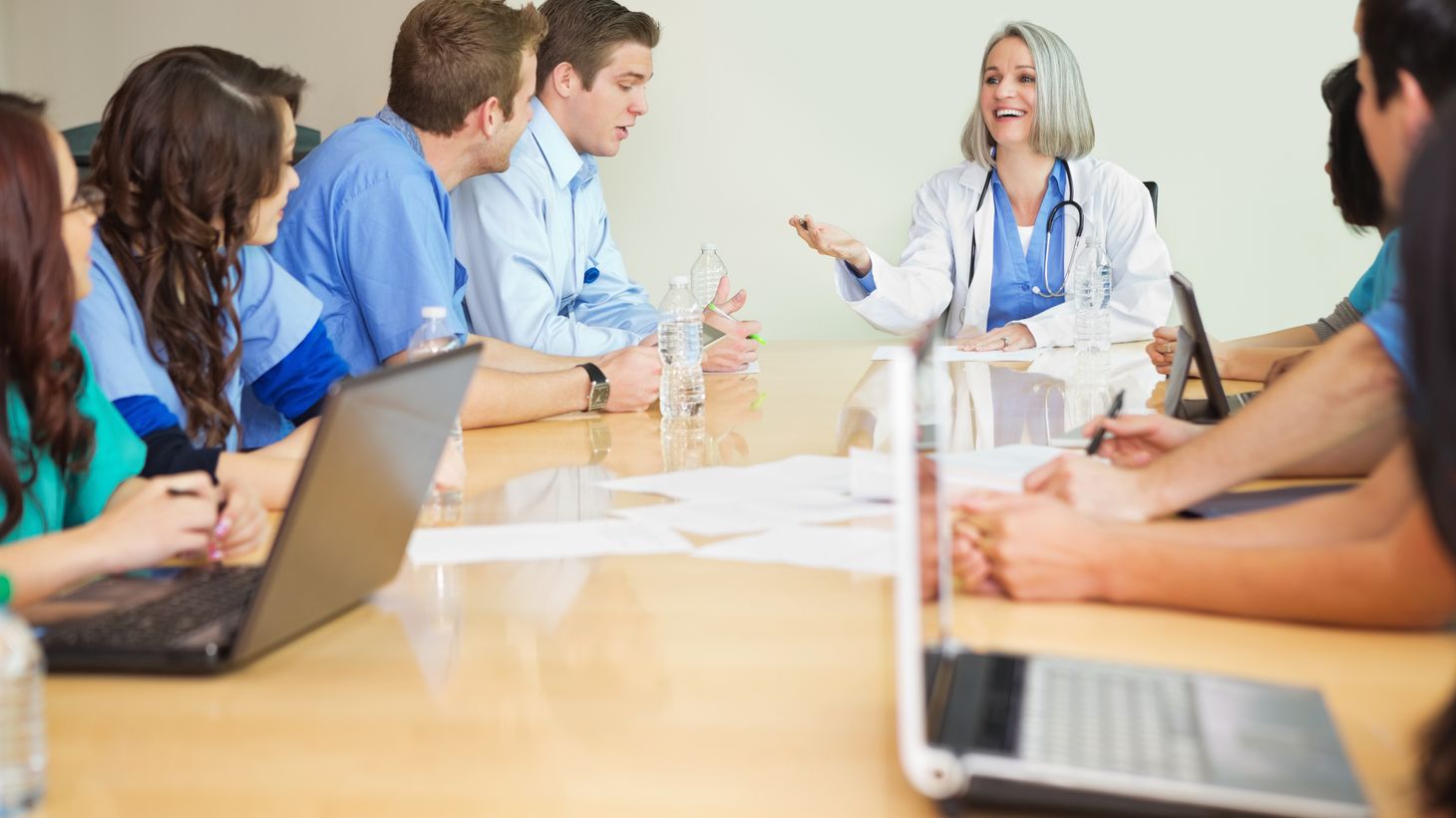 A mix of healthcare professionals talking around a table