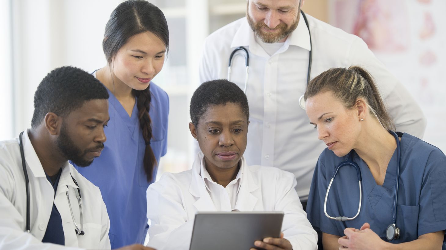 Healthcare professionals looking at a tablet screen