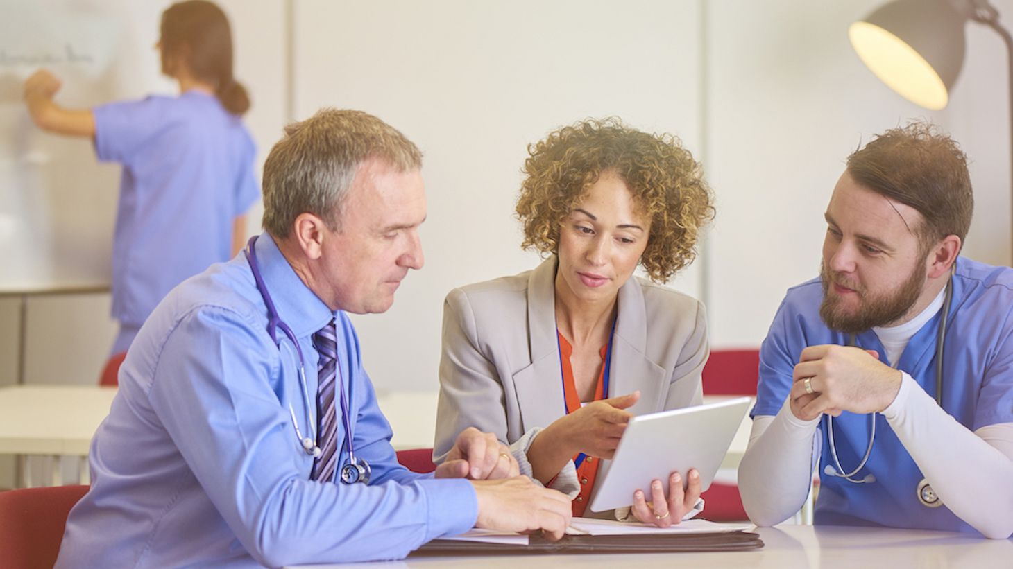 Medical professionals talking and looking at a tablet