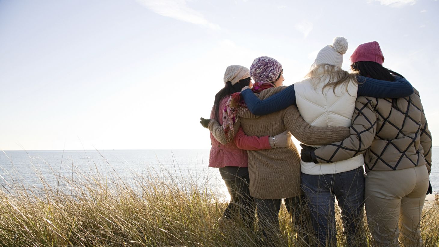 Four women together on a walk on the beach