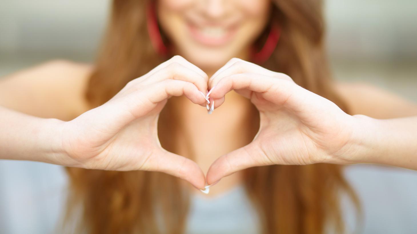 Lady forming her hands into the shape of a heart