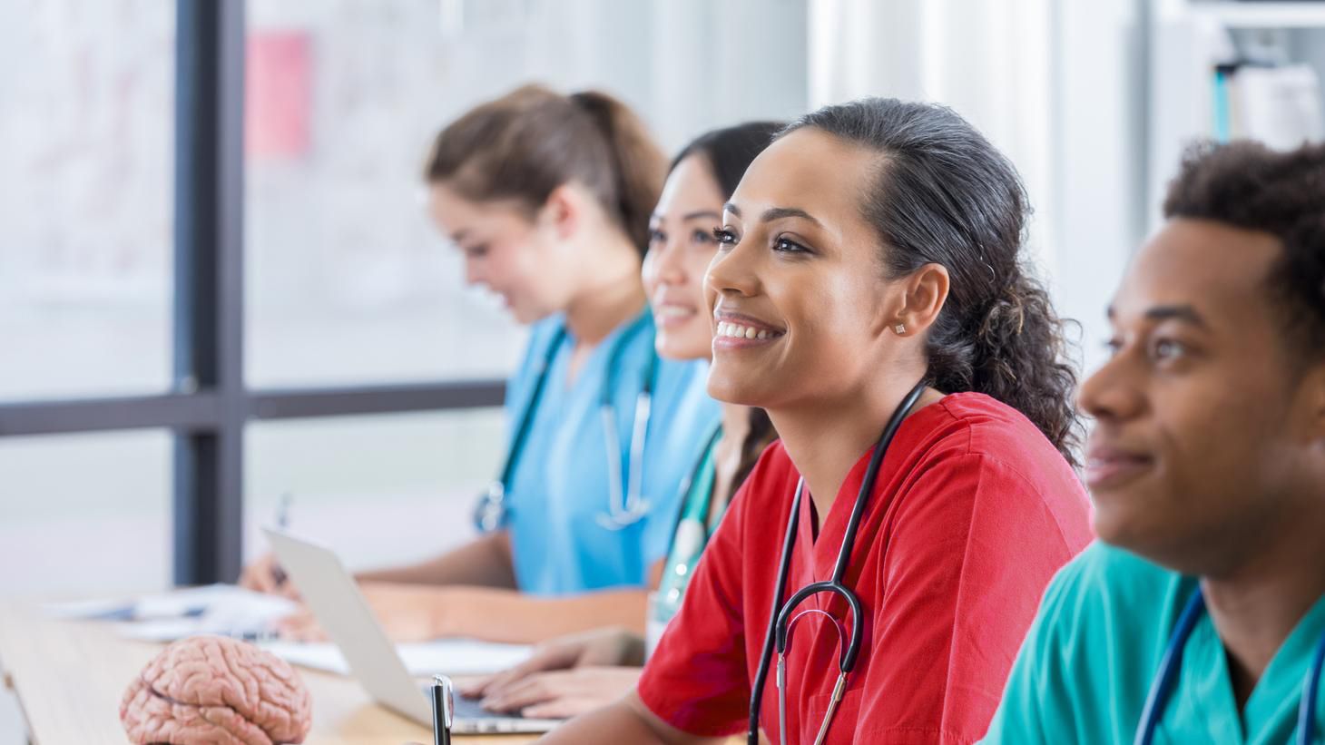 Female nurse sitting at desk smiling