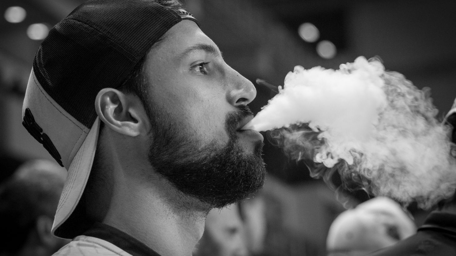 man blowing vape smoke