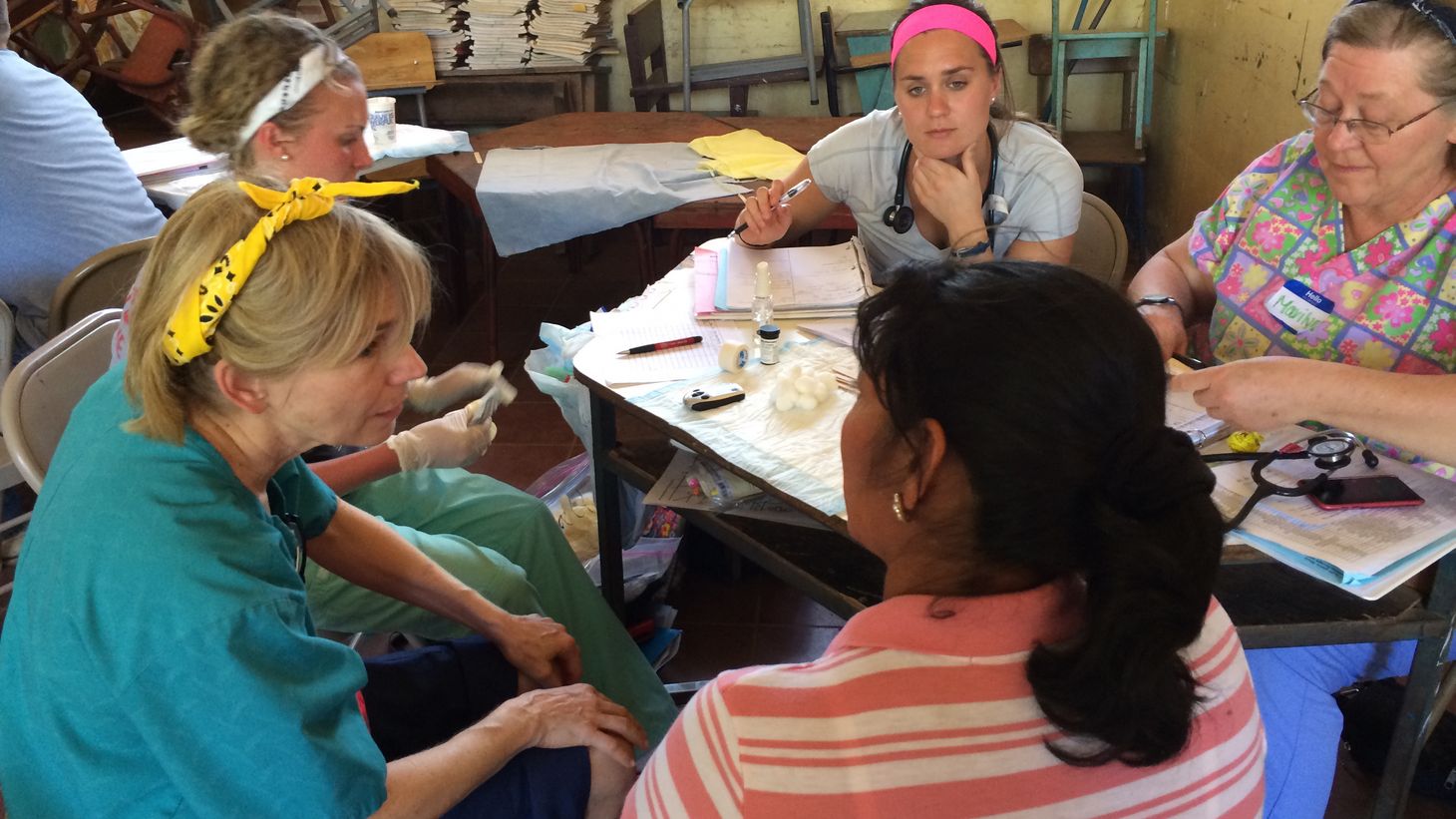 College of Nursing faculty and students in Honduras talking around a table