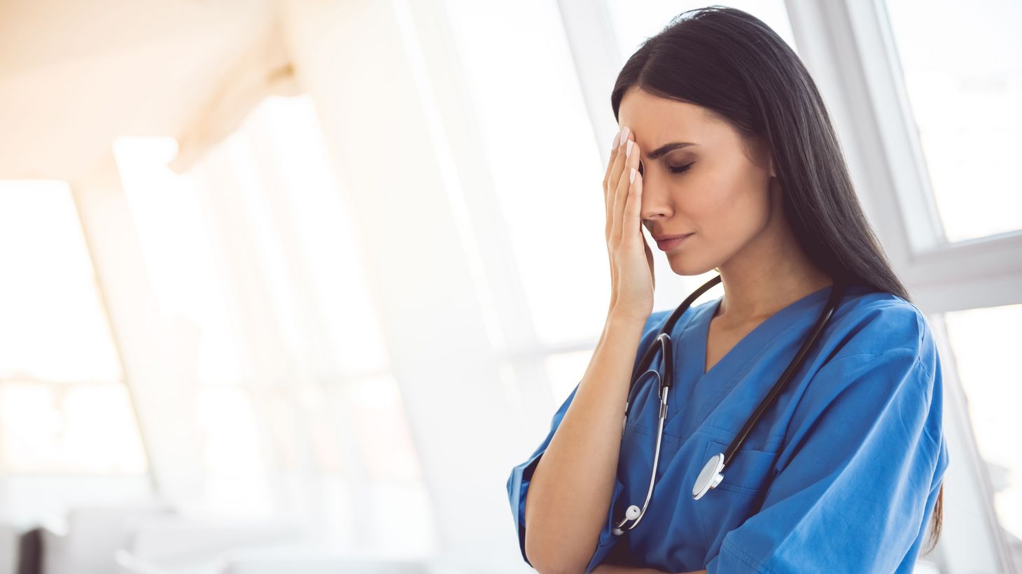 stressed nurse with hand on forehead
