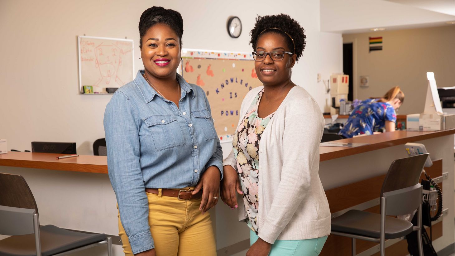 two women standing by nurses station