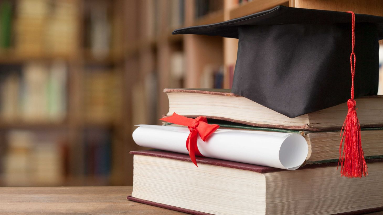 graduation cap on stack of books