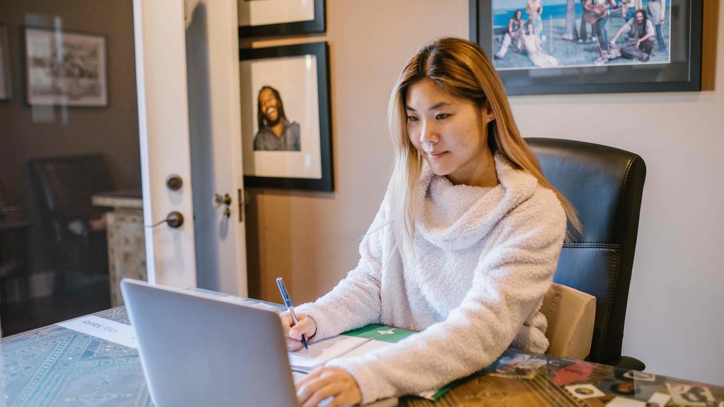 woman in white sweater using silver laptop