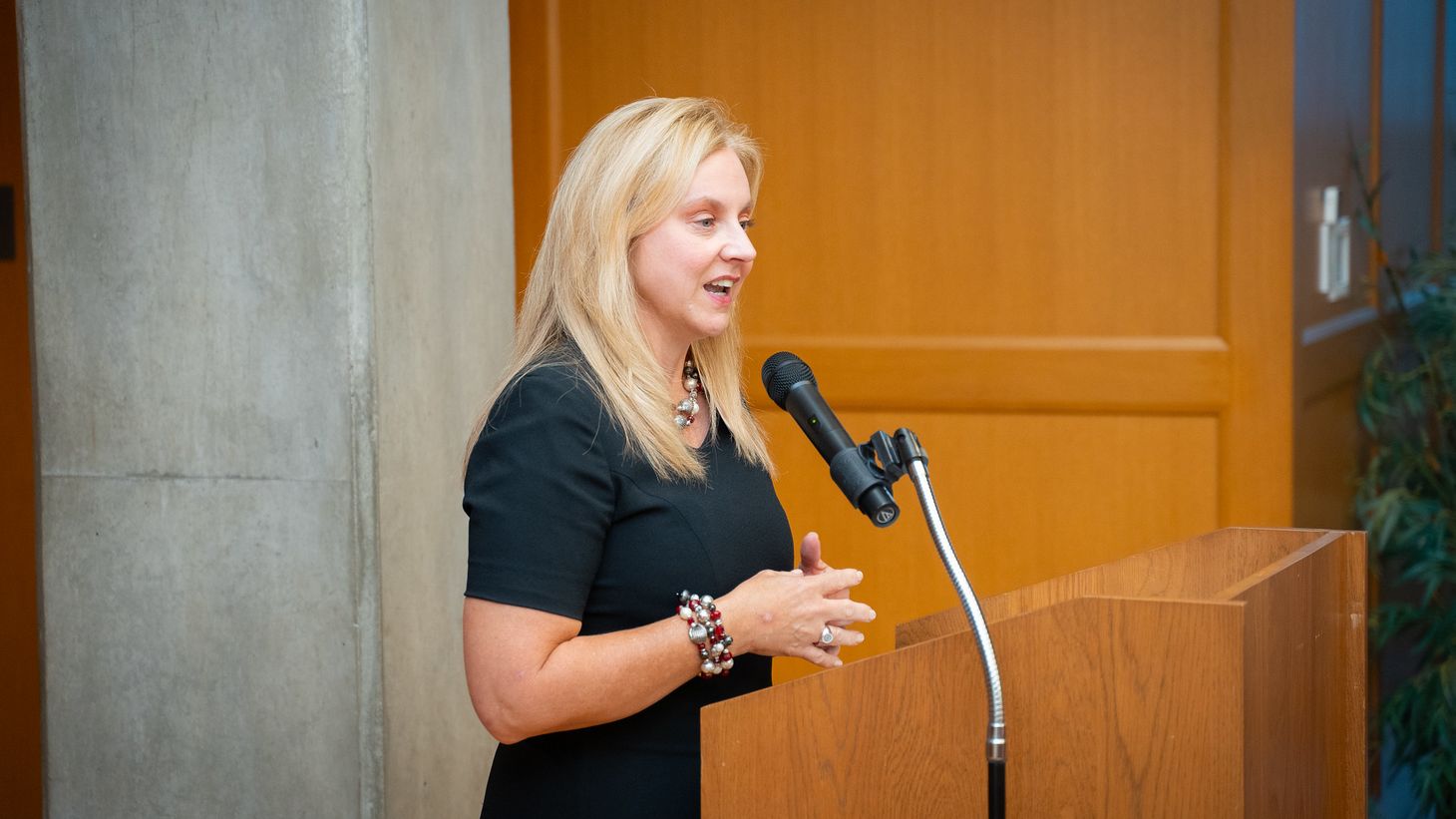 Christine Fortney standing behind a podium speaking during Alumni Society Awards event