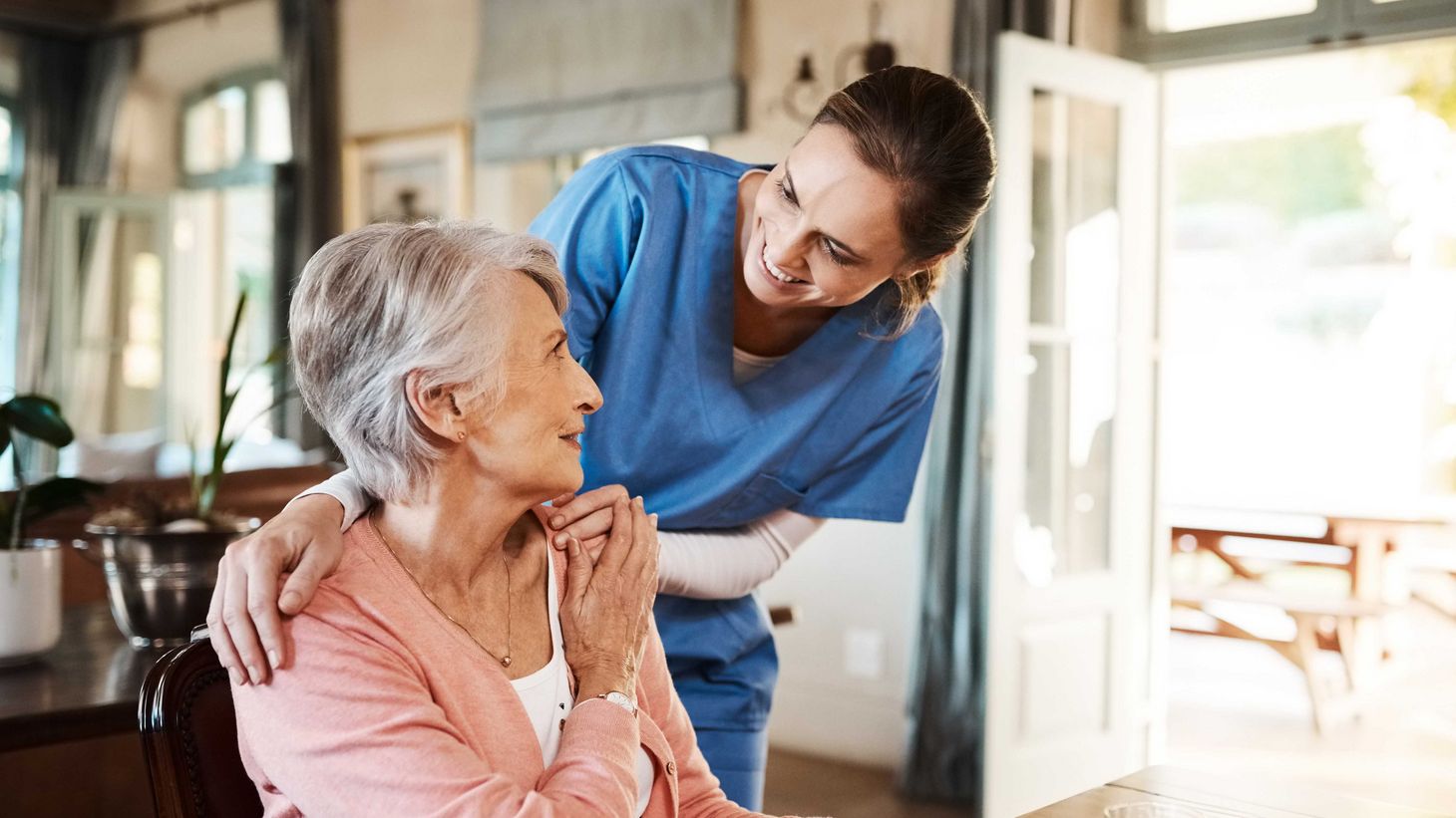 nurse helping elderly woman eat breakfast