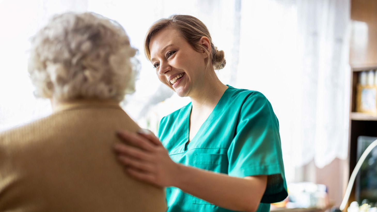 Friendly nurse supporting an elderly lady
