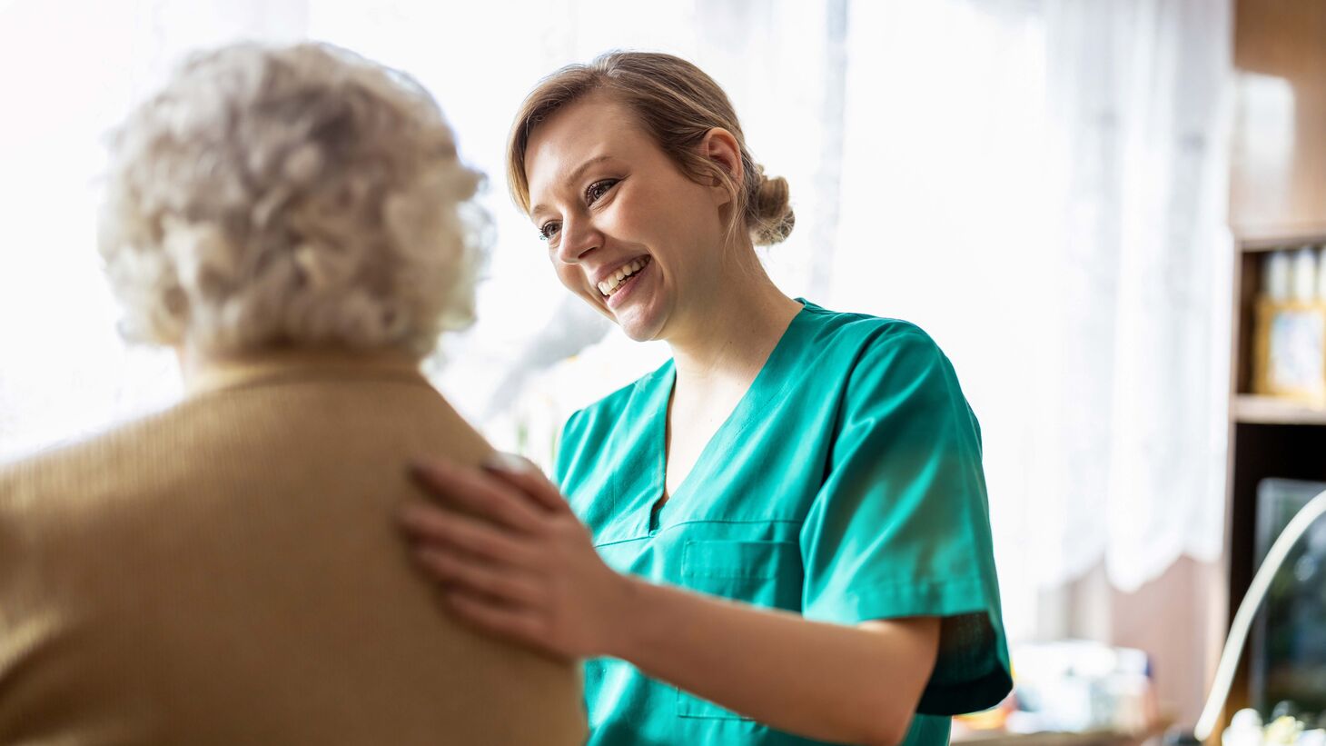 Friendly nurse supporting an elderly woman