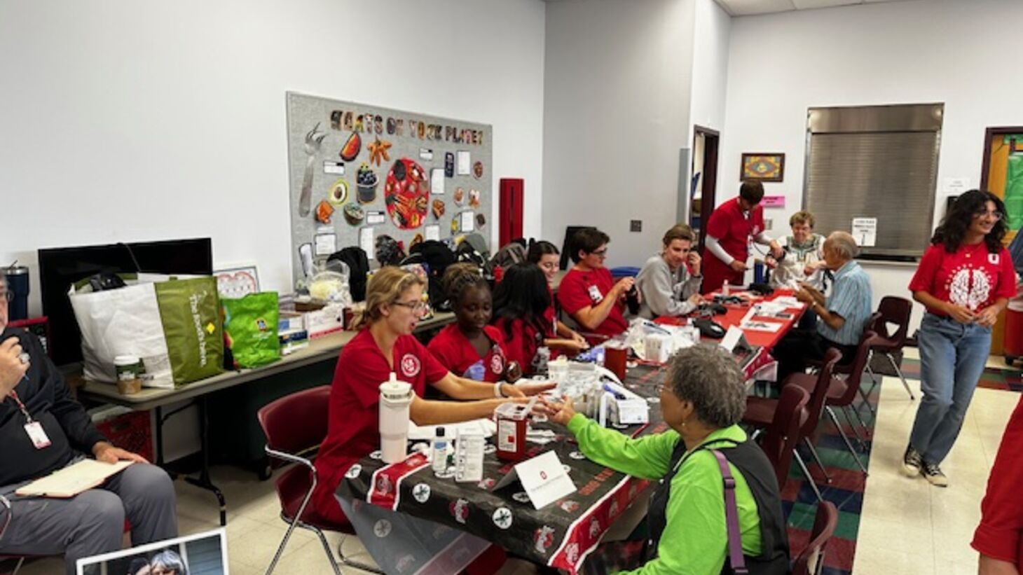 Ohio State nursing students providing health screenings including blood pressure and glucose monitoring.