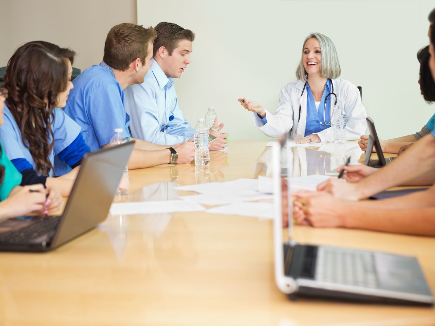 A mix of healthcare professionals talking around a table
