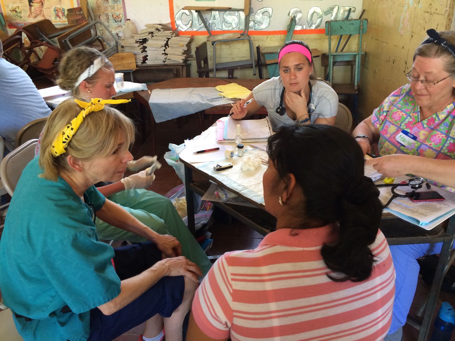 College of Nursing faculty and students in Honduras talking around a table