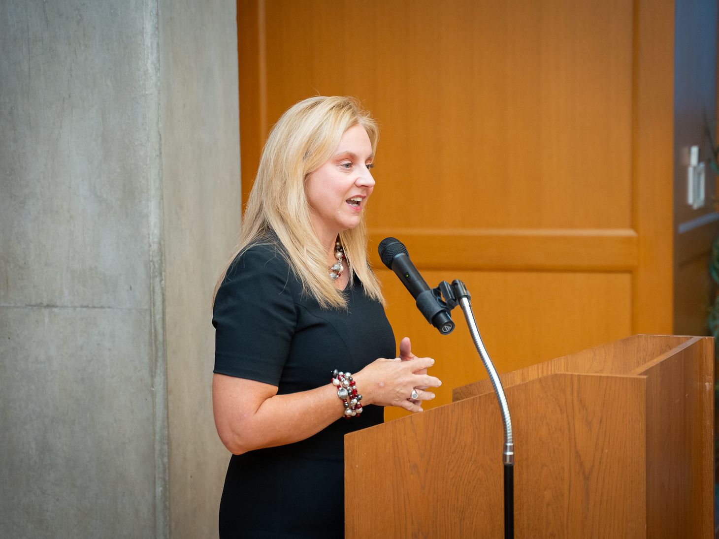 Christine Fortney standing behind a podium speaking during Alumni Society Awards event