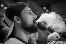 man blowing vape smoke
