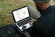 man sitting outside using laptop computer