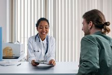 Healthcare provider at desk reviewing information with patient