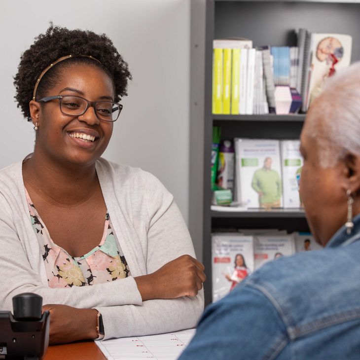 black woman sitting at desk with patient
