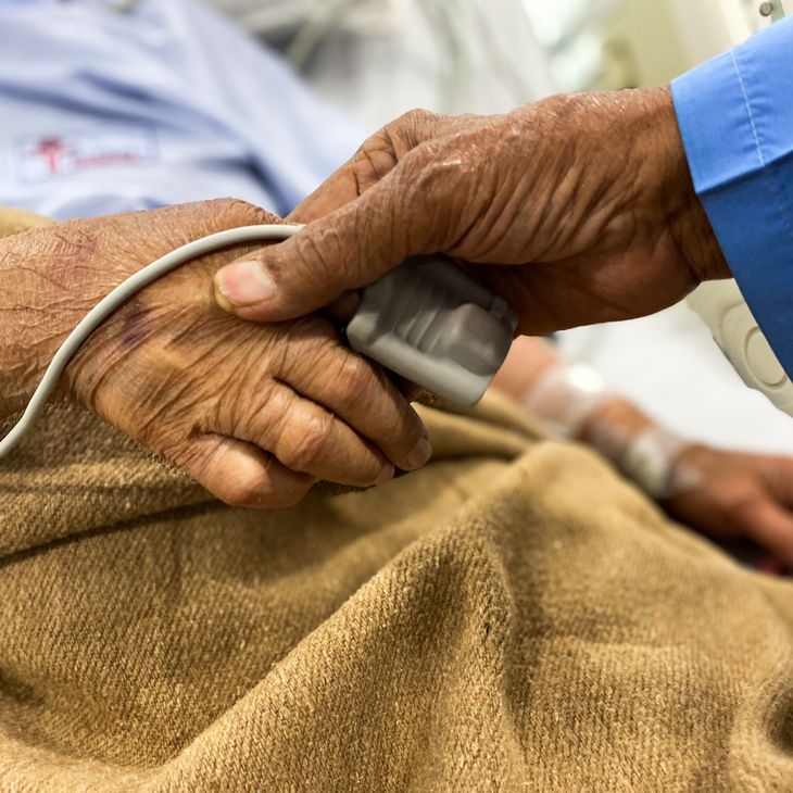 Healthcare provider taking pulse of patient