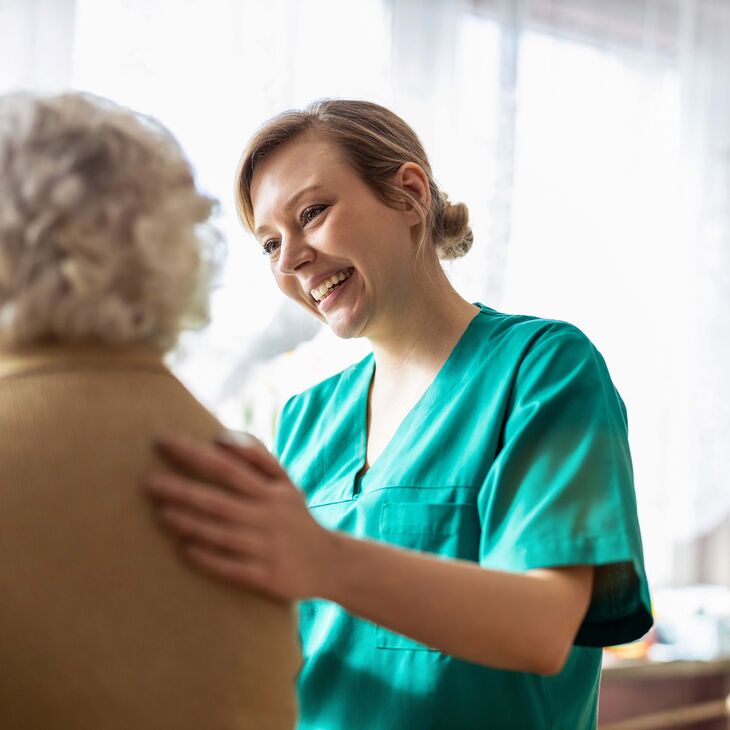 Friendly nurse supporting an elderly woman