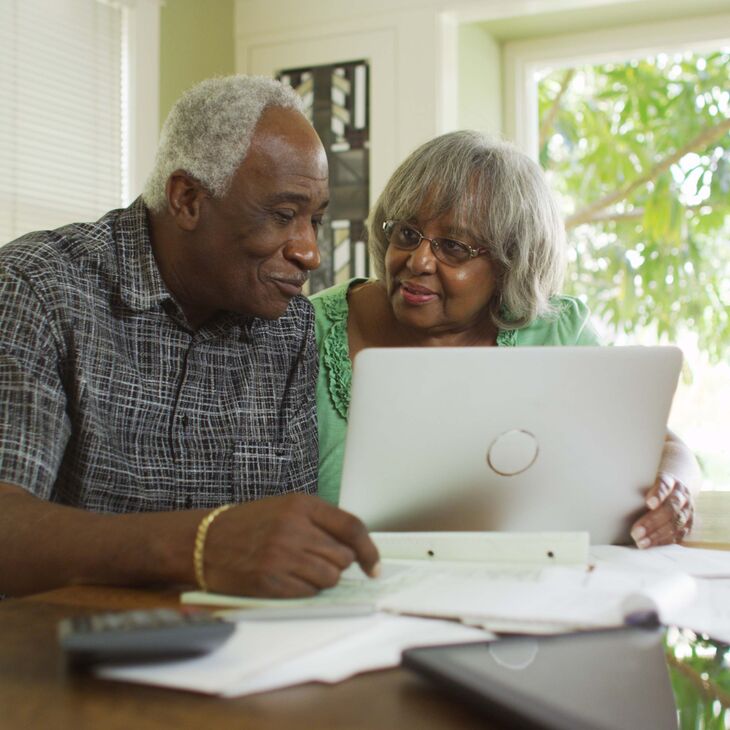 African American senior man and woman looking at laptop together
