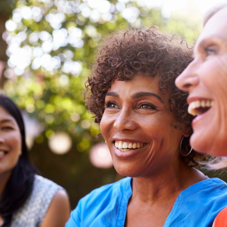 3 older women outside laughing and smiling