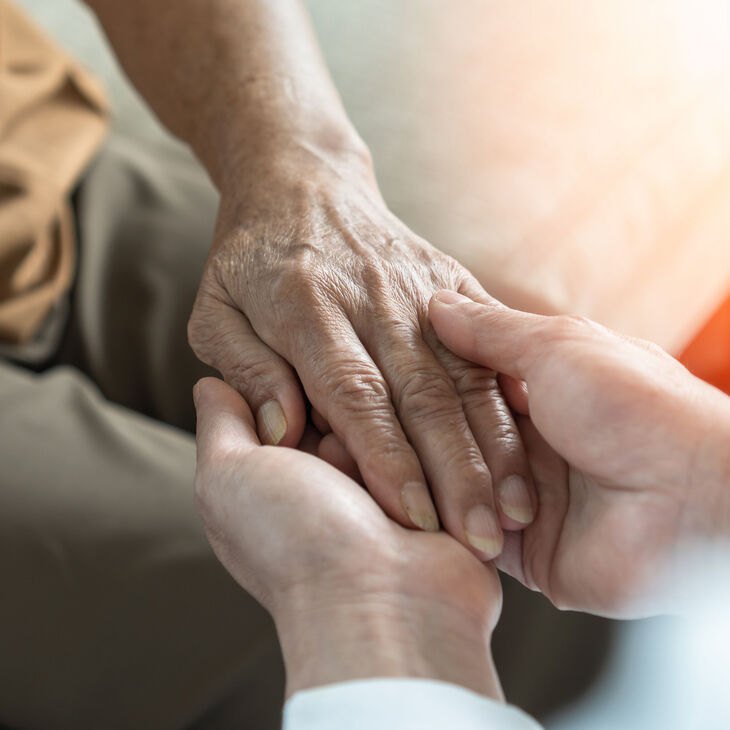 Hands holding an elderly person's hand