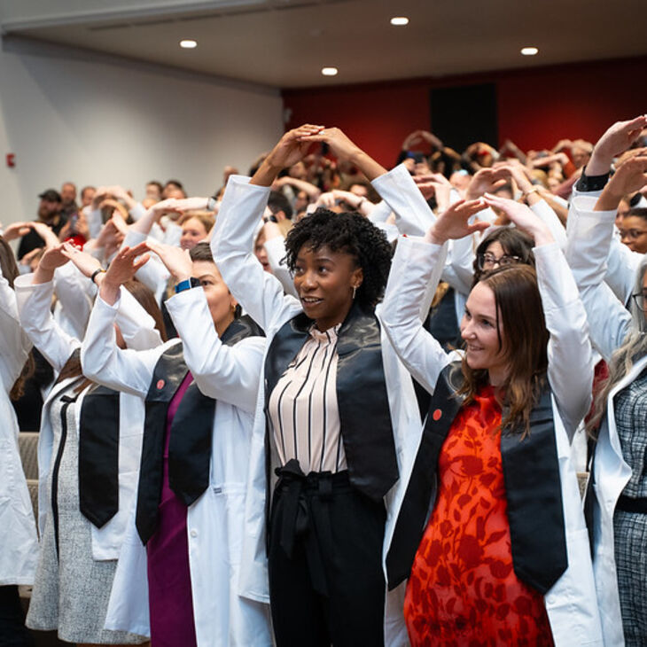 students in white coats singing Carmen Ohio
