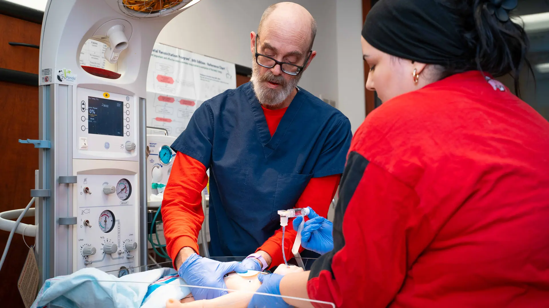 students practice on a nursing simulation baby