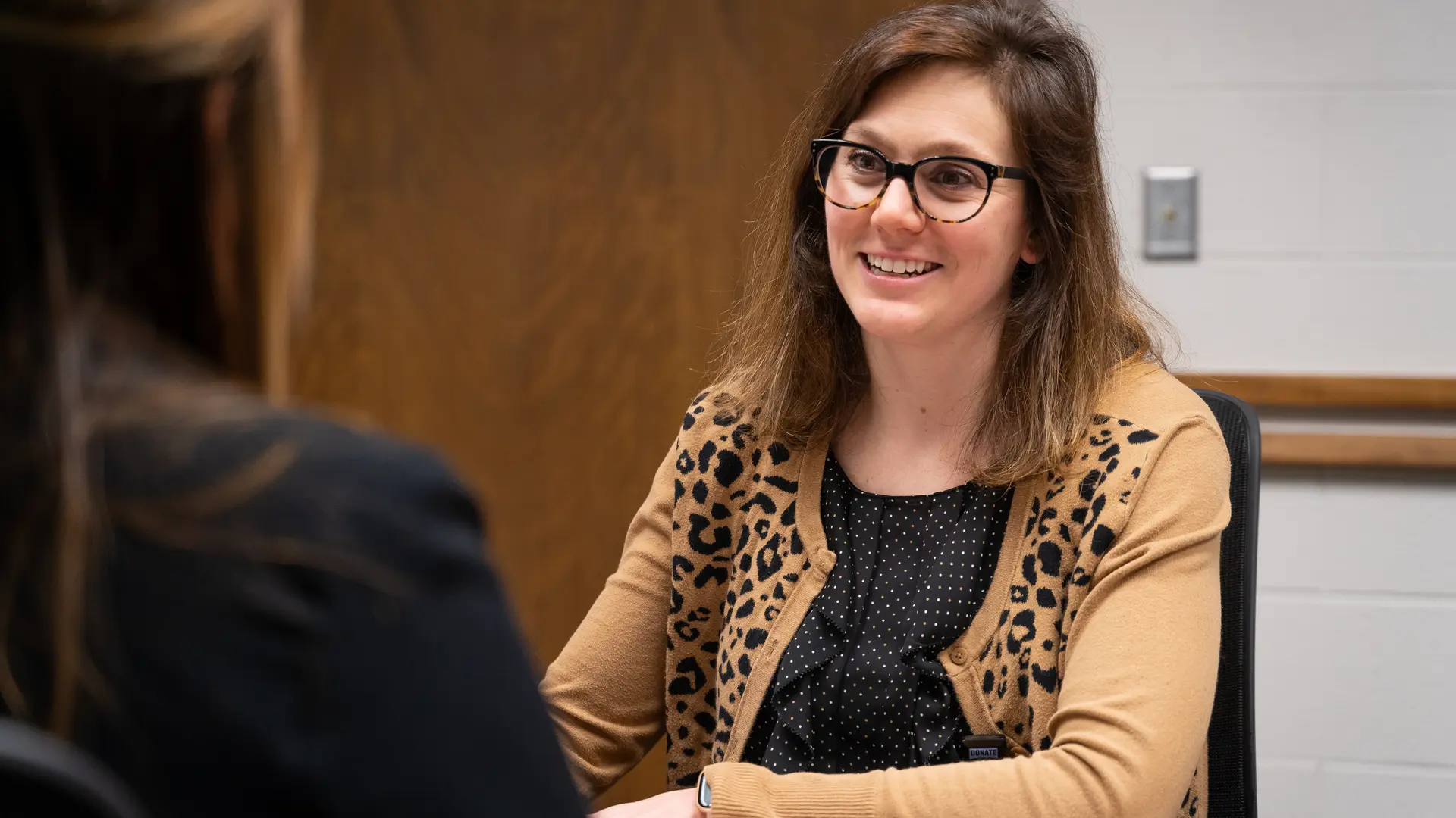 a person sits and talks with a student