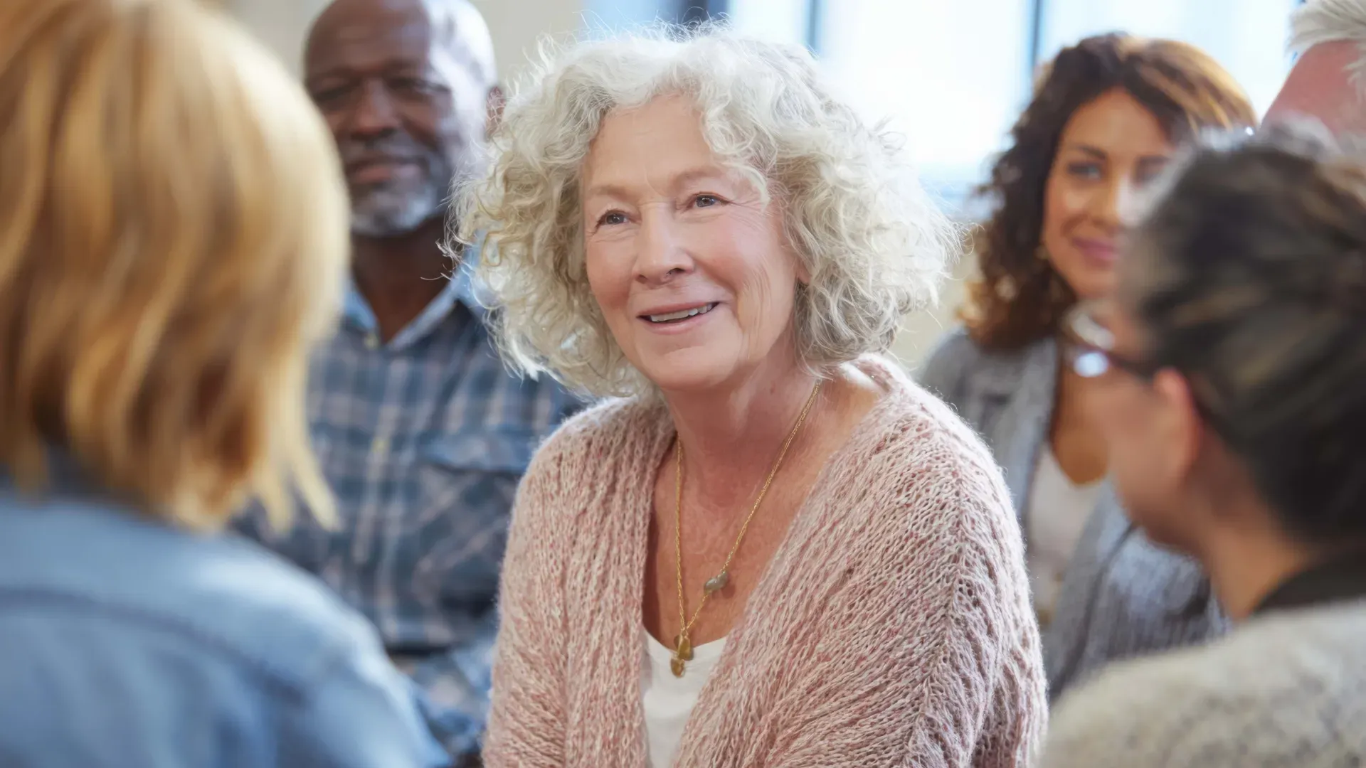 Elderly woman sitting with a group