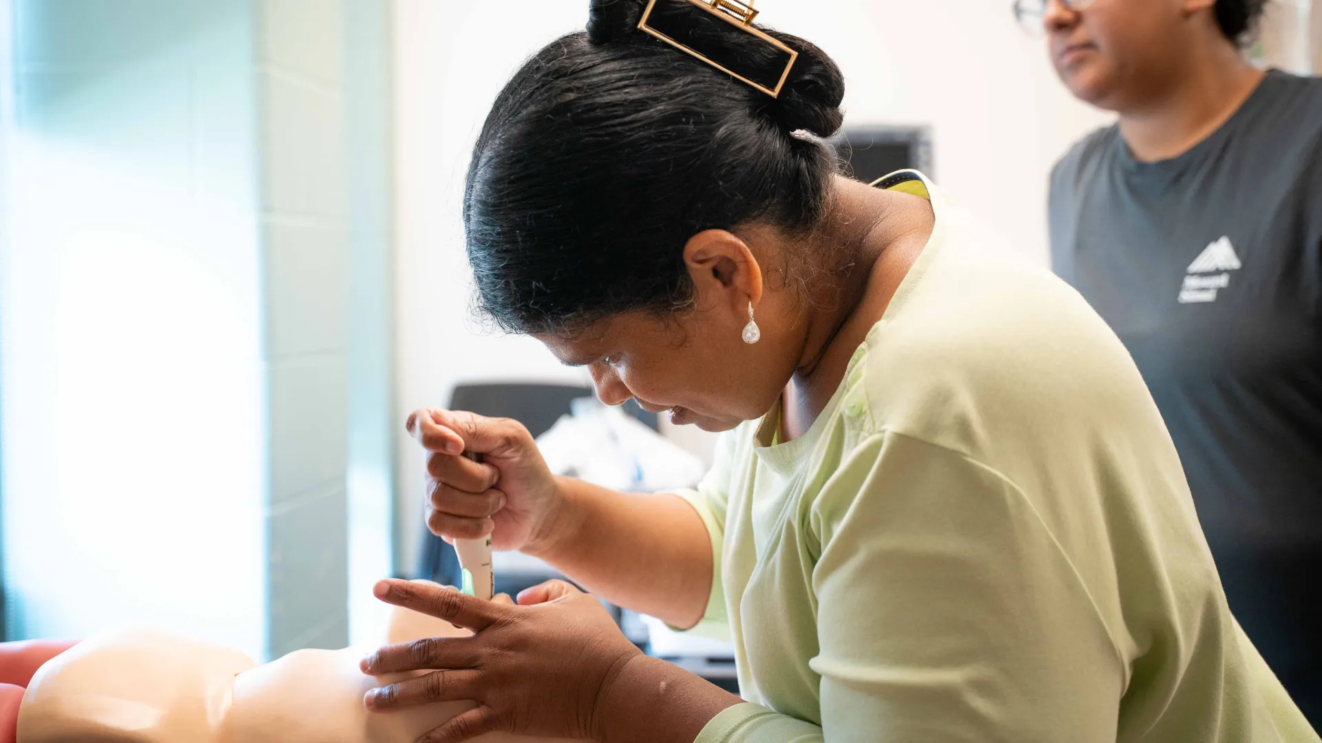 student works on dummy patient during lab