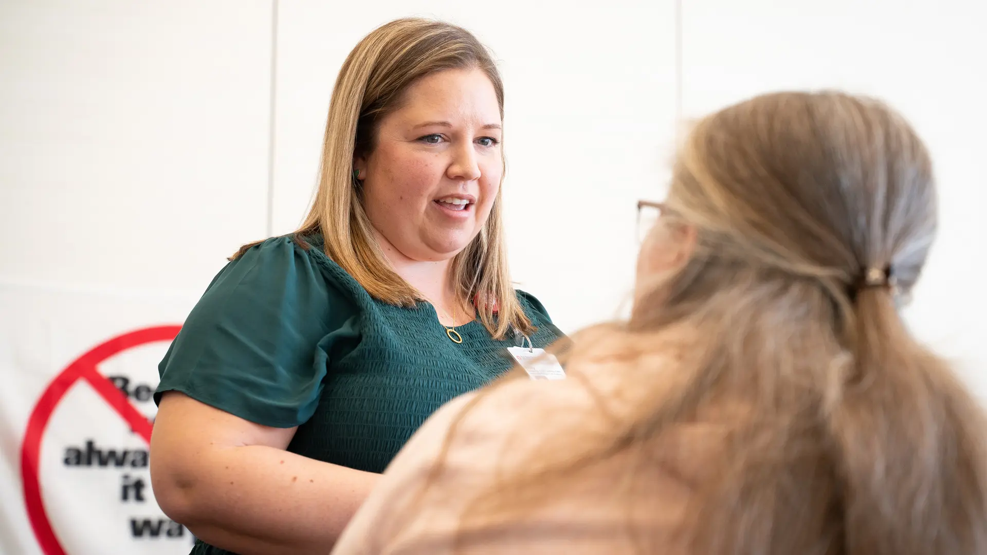 person at front of a classroom leading a group of nurses in a workshop