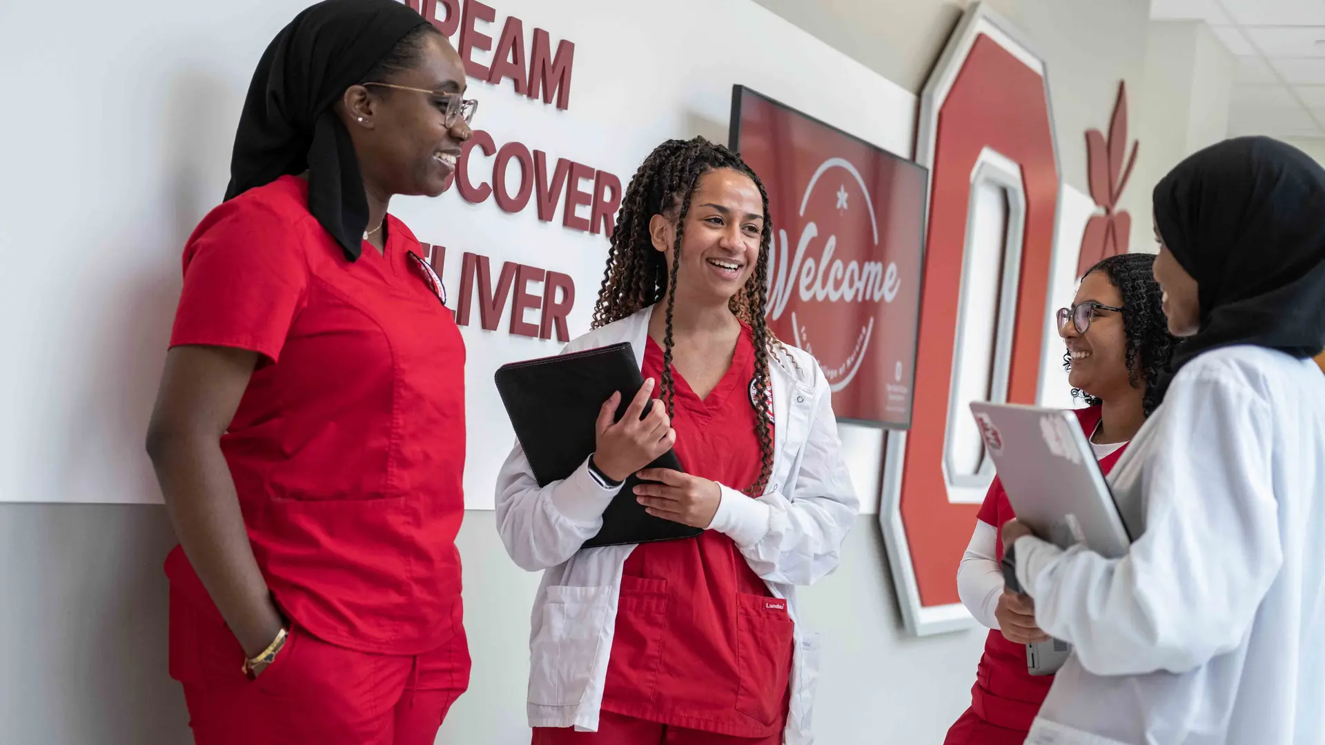 BSN students in red scrubs talking in Heminger Hall