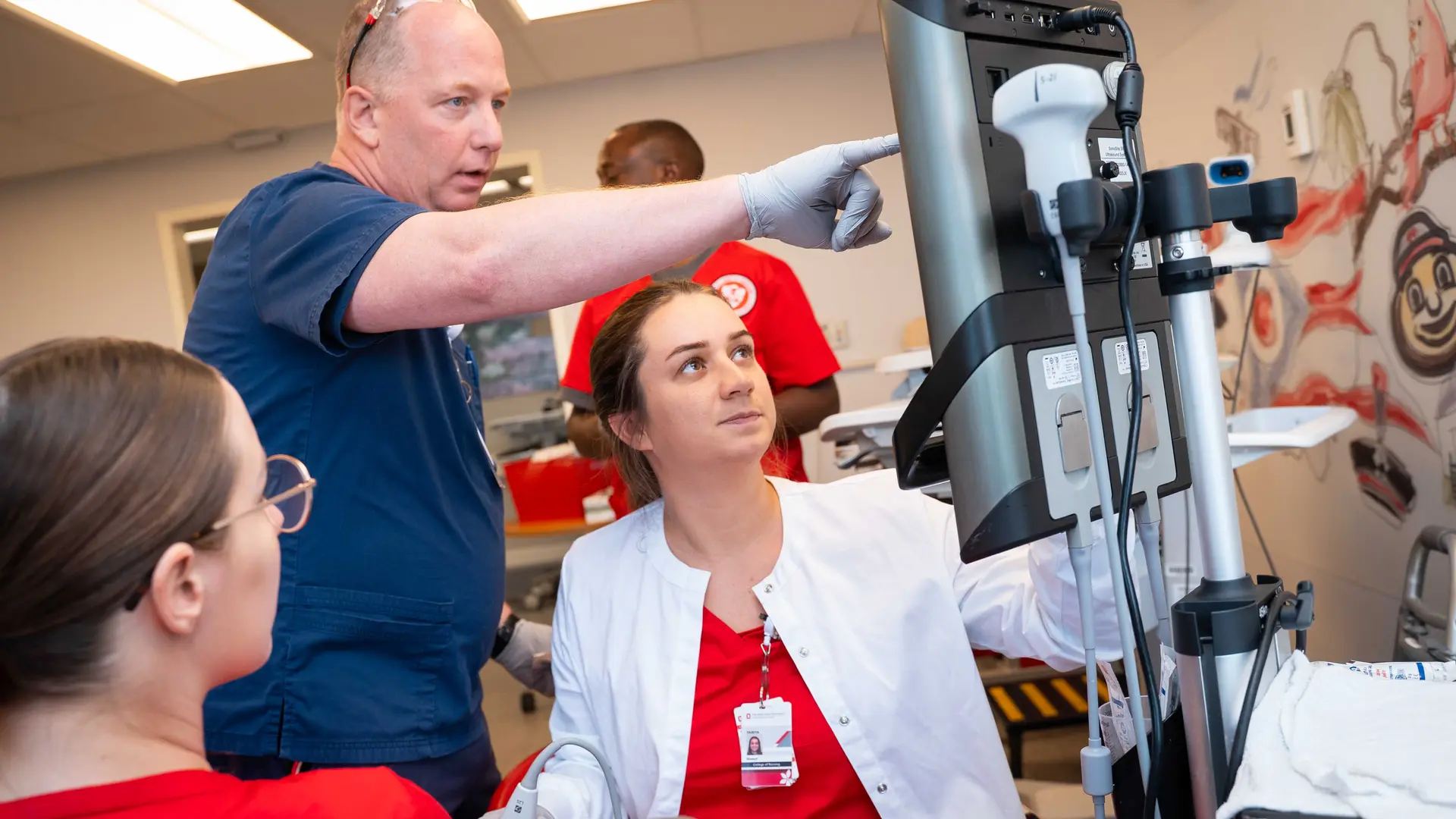 clinical instructor with nursing students points to monitor