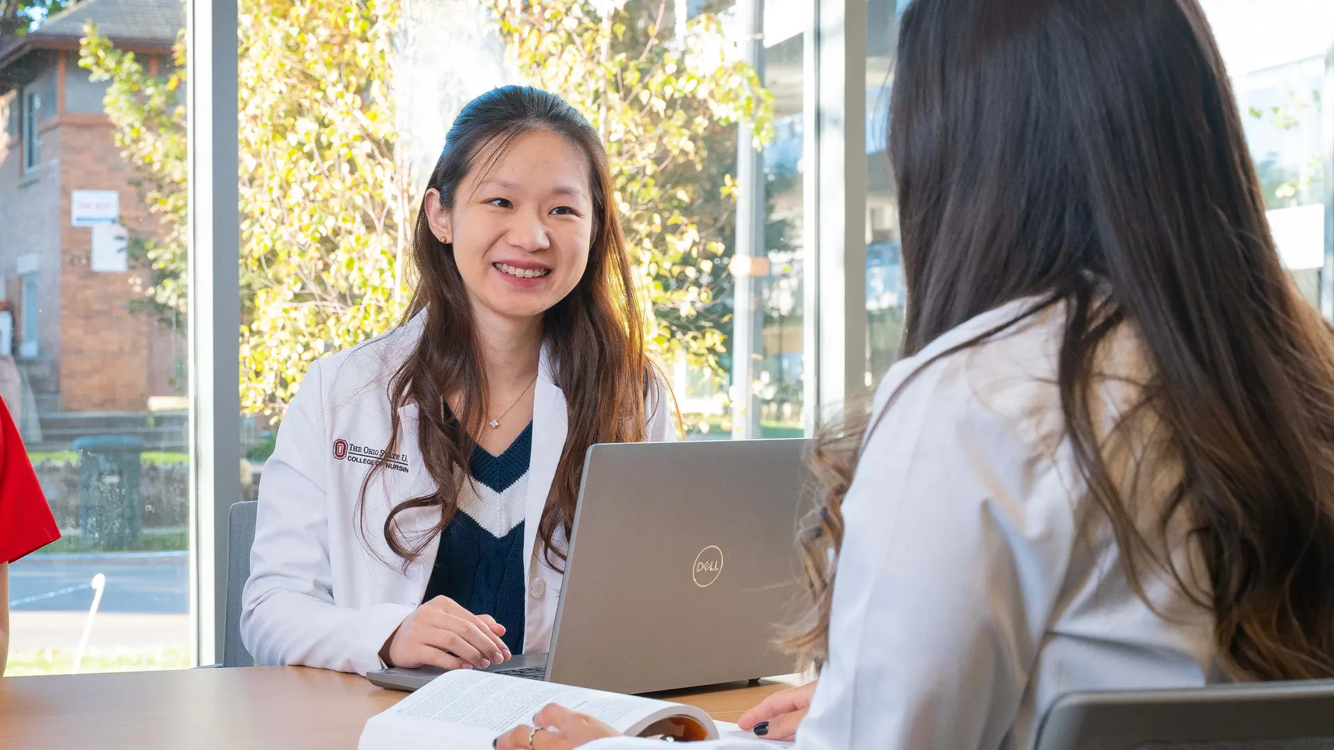 Students in white coats working on computer